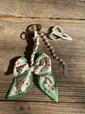 Butterfly-shaped keychain with floral design on a wooden surface