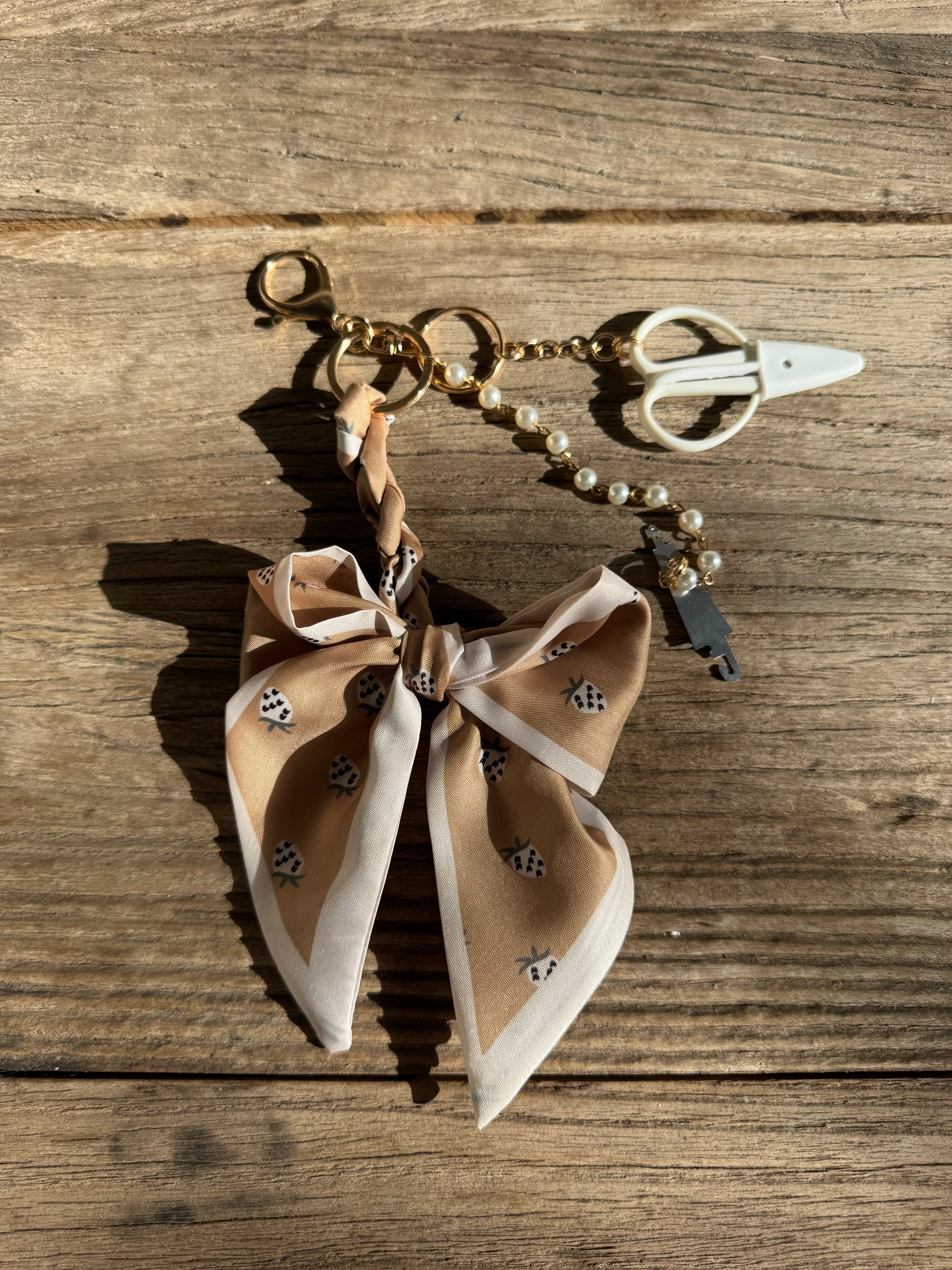 Keychain with a bow and decorative elements on a wooden surface