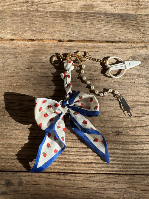 Decorative keychain with a bow on a wooden surface