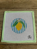 Embroidery hoop with a lemon design on a wooden surface