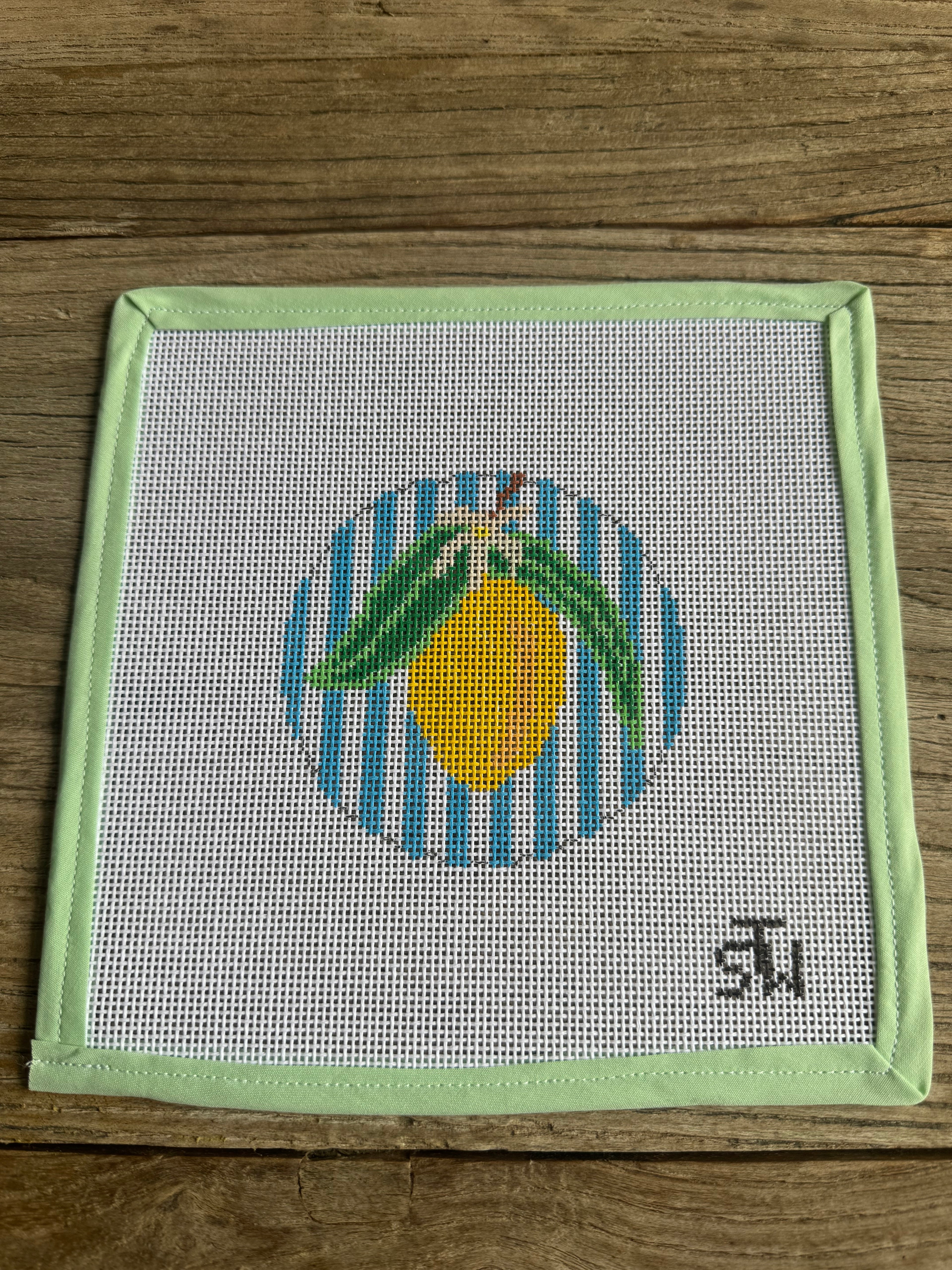 Embroidery hoop with a lemon design on a wooden surface